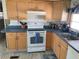 Efficient kitchen with white appliances, wood cabinets, and a gas cooktop at 218 Trailorama Dr, North Port, FL 34287