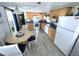 Open concept kitchen with dining area, white appliances, and wood cabinets at 218 Trailorama Dr, North Port, FL 34287