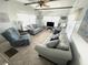Relaxing living room with two sofas, a recliner, and a large TV at 218 Trailorama Dr, North Port, FL 34287