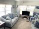 Spacious living room with light colored sofas and nautical themed decor at 218 Trailorama Dr, North Port, FL 34287
