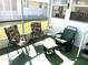 Screened porch with chairs and small table at 218 Trailorama Dr, North Port, FL 34287