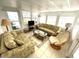 Sunroom with tiled floor, two sofas, and wicker chair, offering ample natural light at 218 Trailorama Dr, North Port, FL 34287