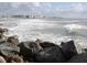 Waves crashing on rocks with city skyline in the background at 235 Base E Ave # 201, Venice, FL 34285