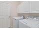 Laundry room with washer, dryer, and ample cabinet storage at 23924 Skyflower Ct, Venice, FL 34293