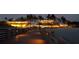 Beachside restaurant at dusk with a picturesque, illuminated dining area under palm trees on a warm night at 250 Santa Maria St # 219, Venice, FL 34285