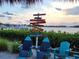 Scenic view of Nokomis Beach with directional signs, inviting chairs, and picturesque waterfront views at 250 Santa Maria St # 219, Venice, FL 34285