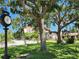 Charming street view with mature trees and well-maintained street clock by a building complex at 250 Santa Maria St # 219, Venice, FL 34285