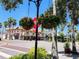 Exterior view of shops with hanging flower baskets, nestled among palm trees and well-maintained landscaping at 250 Santa Maria St # 219, Venice, FL 34285