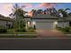 Single-story house with a two-car garage, showcasing a lovely sunset view at 2539 Brassica Dr, North Port, FL 34289