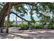 Outdoor seating area under large oak trees near water at 3157 Willow Springs Cir, Venice, FL 34293