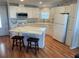 L-shaped kitchen with island and white cabinets at 334 Blackburn Blvd, North Port, FL 34287