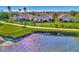Aerial perspective of homes situated alongside a golf course and tranquil lake at 4245 Whispering Oaks Dr, North Port, FL 34287