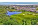 Aerial view showcasing houses near a golf course and serene lake at 4245 Whispering Oaks Dr, North Port, FL 34287