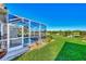 Spacious backyard with screened pool and lush landscaping at 4245 Whispering Oaks Dr, North Port, FL 34287