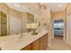 Double vanity bathroom with a large mirror and walk-in shower at 4245 Whispering Oaks Dr, North Port, FL 34287