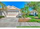 Two-car garage, mature landscaping, and a paved driveway at 4245 Whispering Oaks Dr, North Port, FL 34287