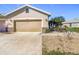 Tan garage door and well-manicured landscaping at 4334 Lenox Blvd, Venice, FL 34293