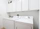 Bright laundry room with washer, dryer, and ample cabinet space at 4334 Lenox Blvd, Venice, FL 34293