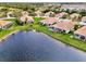 Aerial view of a lakefront community with numerous houses at 4980 Whispering Oaks Dr, North Port, FL 34287