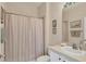 Cozy bathroom featuring a shower with curtain, a functional toilet, and an under-sink cabinet at 4980 Whispering Oaks Dr, North Port, FL 34287