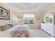 Serene bedroom featuring tray ceilings and a lovely view of the outdoors at 4980 Whispering Oaks Dr, North Port, FL 34287