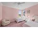 Bright bedroom featuring two twin beds, comfortable chair, and a ceiling fan for added comfort at 4980 Whispering Oaks Dr, North Port, FL 34287