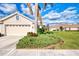 Home exterior showcasing a two-car garage and well-manicured landscaping at 4980 Whispering Oaks Dr, North Port, FL 34287