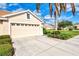 Attached garage with a double door and landscaped surroundings at 4980 Whispering Oaks Dr, North Port, FL 34287