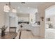 Bright kitchen featuring white cabinets, white appliances, tile floors, and modern lighting at 4980 Whispering Oaks Dr, North Port, FL 34287