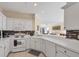 Bright kitchen featuring white cabinets and appliances, and a decorative backsplash at 4980 Whispering Oaks Dr, North Port, FL 34287