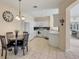 Open concept eat-in kitchen featuring white cabinetry and views into the living area at 4980 Whispering Oaks Dr, North Port, FL 34287