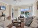 Cozy living room with a view of the lanai, neutral decor, and ample space for entertaining at 4980 Whispering Oaks Dr, North Port, FL 34287