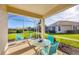 Enclosed patio with comfortable seating and a view of lush backyard and neighborhood pond at 4980 Whispering Oaks Dr, North Port, FL 34287