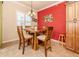 Dining area with wood table and chairs, and red accent wall at 500 San Lino Cir # 521, Venice, FL 34292
