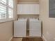 Convenient laundry room with washer, dryer, and overhead cabinets at 500 San Lino Cir # 521, Venice, FL 34292