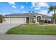 Single-story home with a two-car garage and well-manicured lawn at 52 Fairway Rd, Rotonda West, FL 33947