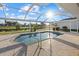 Sparkling pool with caged enclosure offering a serene view of the landscaped backyard and pond at 52 Fairway Rd, Rotonda West, FL 33947