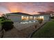 Outdoor oasis featuring a pool, lovely landscaping, and ambient lighting, perfect for evening relaxation at 52 Fairway Rd, Rotonda West, FL 33947