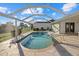 A backyard screened pool with a view of greenery and water features, ideal for relaxation at 52 Fairway Rd, Rotonda West, FL 33947