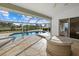 Covered patio with view of pool, screened enclosure, pond and landscaped yard at 52 Fairway Rd, Rotonda West, FL 33947