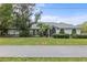 Single-story home with gray roof, landscaping, and long driveway at 97 Robina St, Port Charlotte, FL 33954