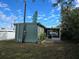 Rear view of green mobile home with screened porch at 113 Ravenna N St, Nokomis, FL 34275