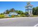 Grand Palm community entrance sign with lush landscaping and palm trees at 11897 Hunters Creek Rd, Venice, FL 34293