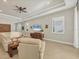 Living room with white leather sectional sofa, large TV, and plantation shutters at 11897 Hunters Creek Rd, Venice, FL 34293