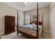 Bedroom with a wooden four-poster bed, dresser, and window with shutters at 12115 Stuart Dr, Venice, FL 34293