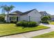 White house with gray roof, two-car garage, and landscaped lawn at 12115 Stuart Dr, Venice, FL 34293