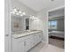 Modern bathroom with double sinks and a view into bedroom at 13307 Pacchio St, Venice, FL 34293