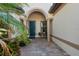 Inviting entryway with arched alcove, dark blue door, and brick-paved floor at 13307 Pacchio St, Venice, FL 34293