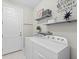 Well-lit laundry room with washer, dryer, and shelving at 13307 Pacchio St, Venice, FL 34293