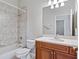Bathroom with wood vanity, tiled shower, and a large mirror at 134 Savona Way, North Venice, FL 34275